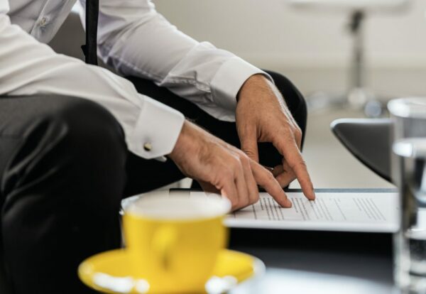 businessman-sitting-at-an-office-coffee-table-proofreading-a-document-1024x684